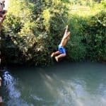 Laotian kids jumping in the water from the bridge