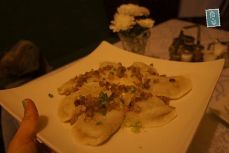A plate of pierogi with fried onion and chives 