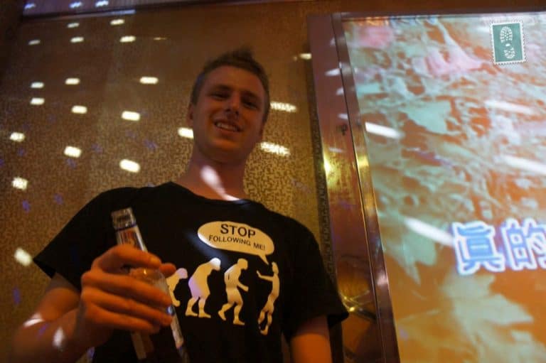 A boy holding a beer in hands in Chinese KTV