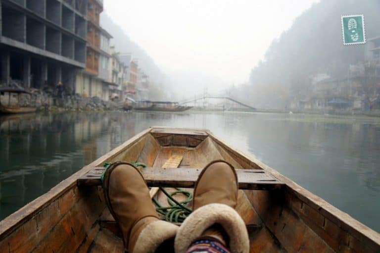 A girl is riding a boat in Fenghuang China