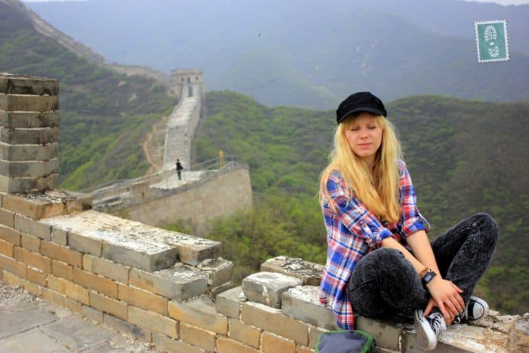 A girl is sitting at the Great Wall of China