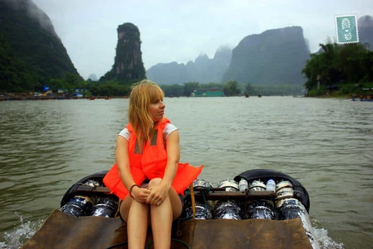 A girl sitting on a bamboo boat Yangshuo River