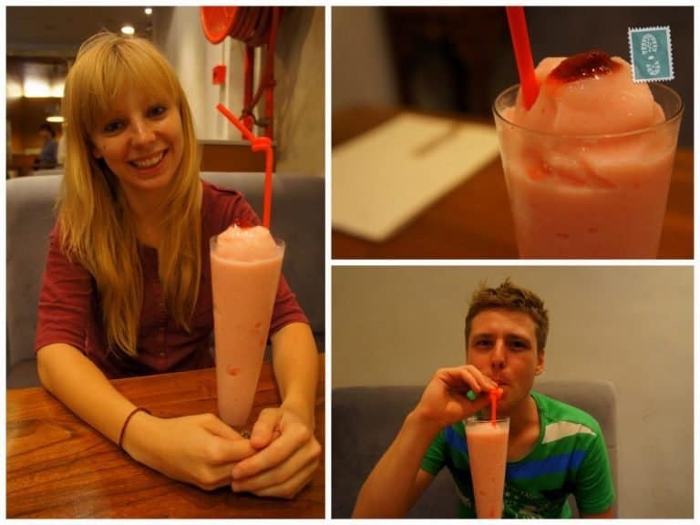 Two people are smiling and drinking a strawberry shake