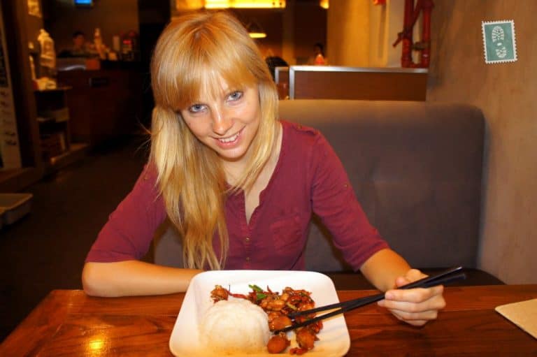 A girl is eating fried chicken with rice in Macau