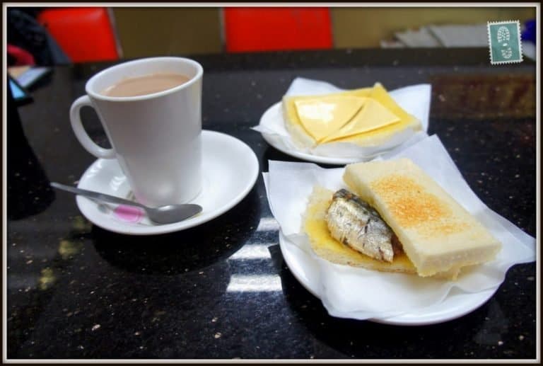 A mug of hot chocolate, ham fried egg and fish sandwich, cheese toast