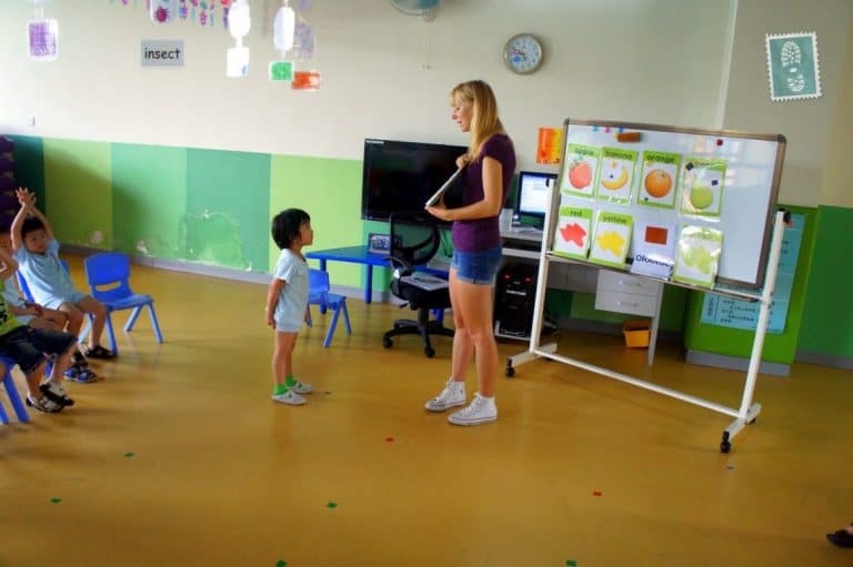 A foreign teacher is teaching fruit vocabulary to Chinese students