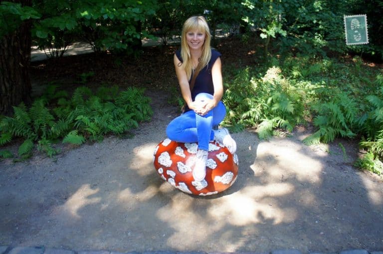 A girl sitting on one of the colorful mushrooms Efteling