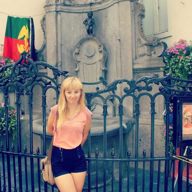 A girl standing in front of the Manneken Pis