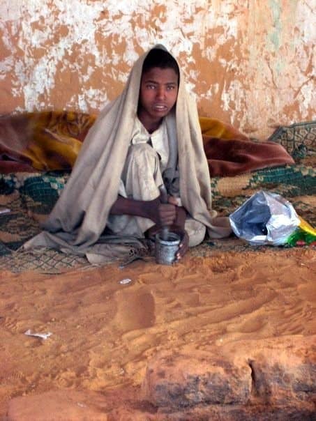 child grinding coffee in sudan