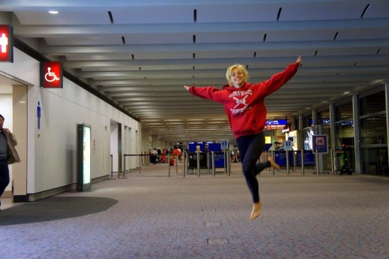 A girl with no shoes jumping at Hong Kong airport