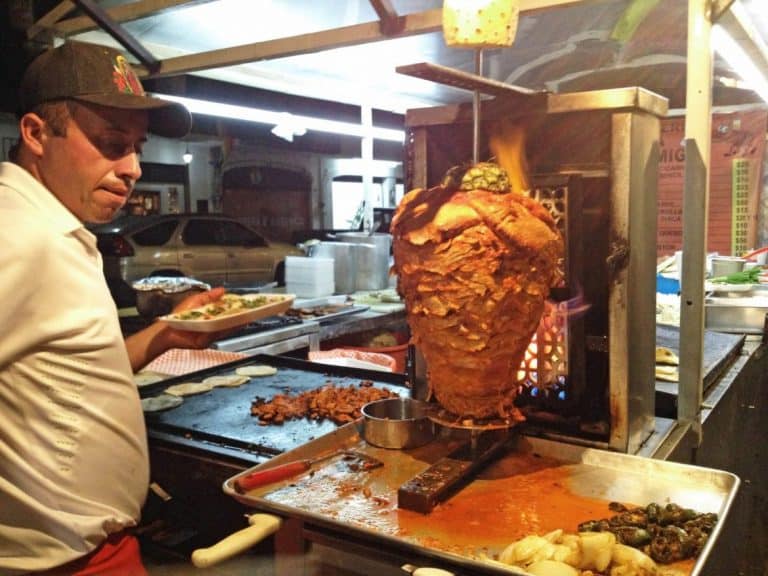 Al Pastor cooking on a spit at a food stand