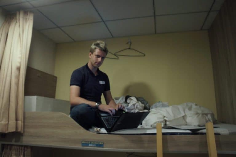 a guy working on a bed in a hostel