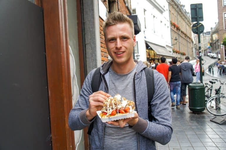 Cez of Etramping is eating a waffle in Brussels