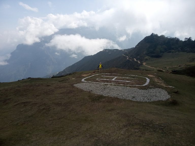 Lydia near a helipad on a mountain