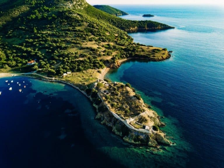 aerial view of rocks and blue sea lagoon in LFQKYD7 aerial view of rocks and blue sea lagoon in LFQKYD7 7 Day Itinerary for Traveling to Greece for the First Time