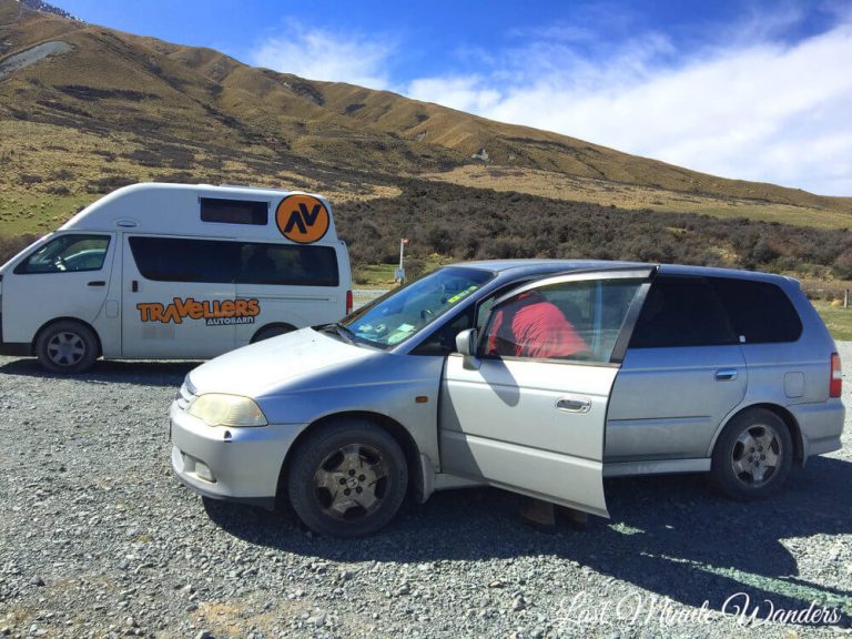 A rental campervan and a smaller camper car parked up at the side of a mountain.