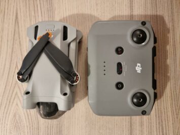 controller drone and remote side by side on wooden floor