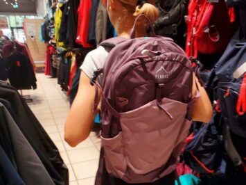 red and pink backpack carrying lady in store