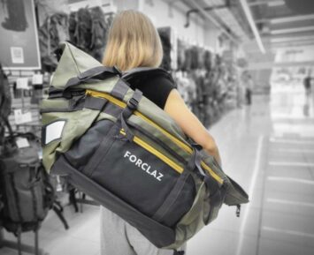 woman carrying large black duffel backpack empty store