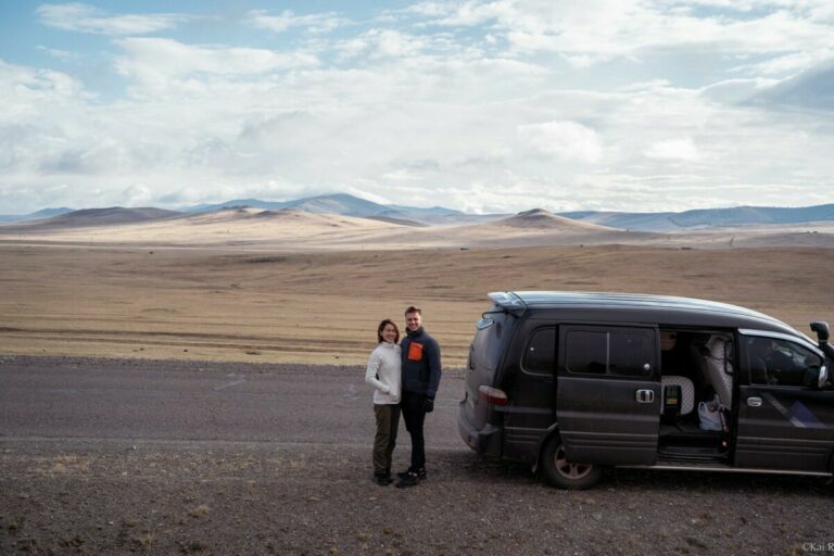 lydia and cez posing in mongolia outside a car